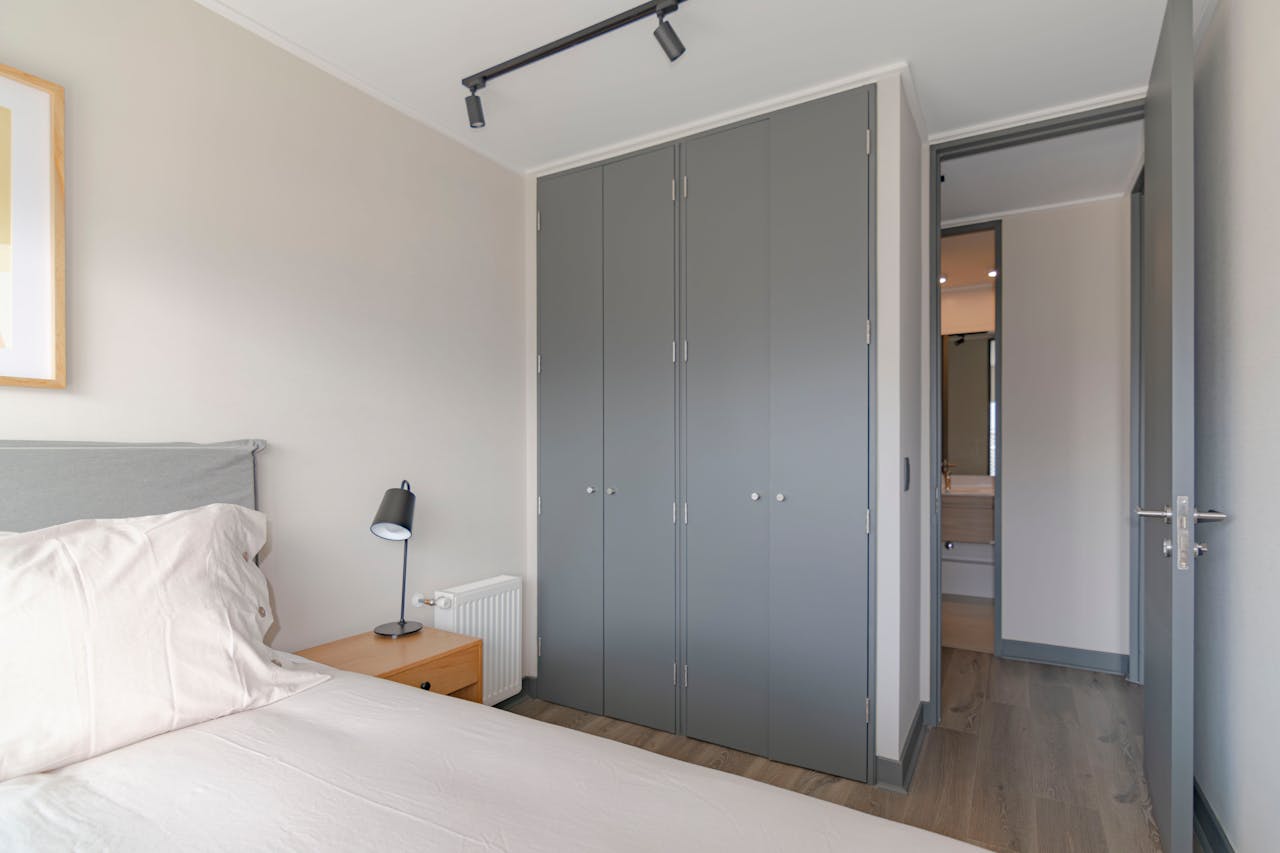 hero-img-02 Contemporary bedroom featuring grey wardrobe and minimal decor, ideal for urban apartments.